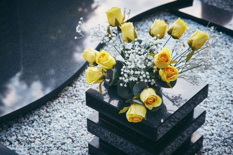 Šopek rumenih vrtnic na grobu.