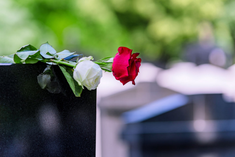 Rdeča in bela vrtnica na nagrobniku.
